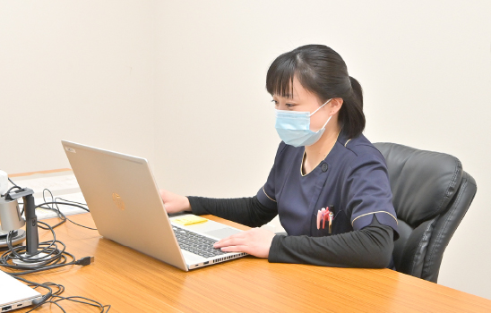新人看護師がパソコンを使い、eラーニングで研修を受けている様子