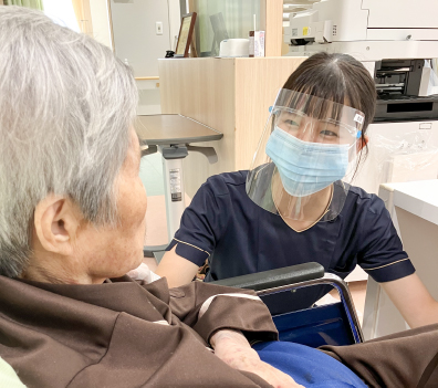 看護師が高齢の患者さまに笑顔で対応している様子