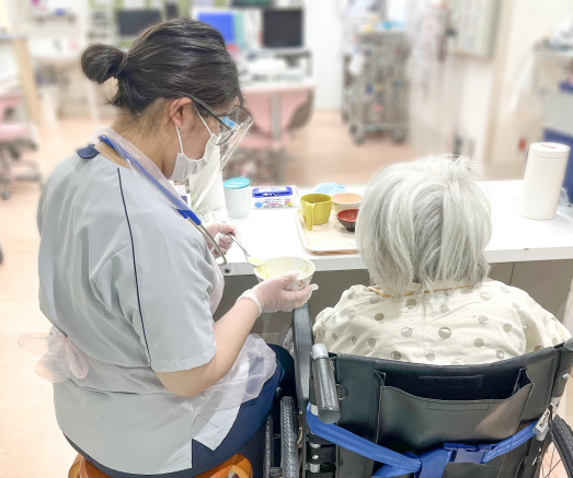 看護師が高齢の患者さまに食事の介護をする様子