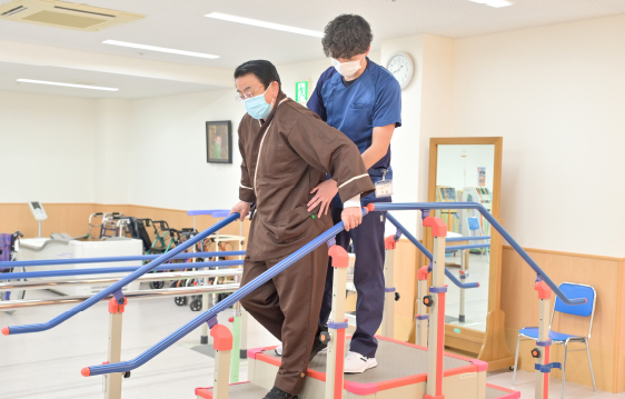 患者さまとリハビリ部スタッフが、階段の上り下りのリハビリを行う様子